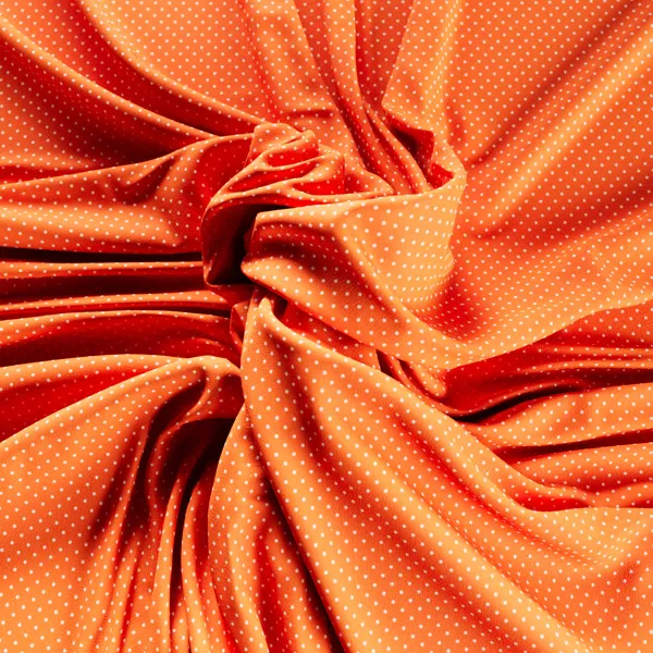 Wrinkled orange polka-dot jersey fabric